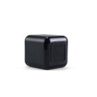 Black cubical device with a glossy finish, featuring a button marked with the letter C on one side. The device is placed against a plain white background.