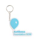 A keychain with a white base and a blue balloon graphic. Below the balloon, the text Asthma Foundation NSW is in blue letters. The keychain is attached to a metal chain and ring.