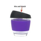 A glass cup with a purple silicone grip and a black plastic lid, labeled Mix and Match. The lid is slightly tilted.