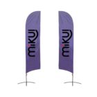 Two vertical purple flags with the word miku in black and a red dot above the i. The flags are mounted on metal stands with cross-shaped bases, set against a plain white background.