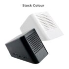 Two small, cube-shaped speakers with grid-patterned fronts. One speaker is black and the other is white. Both have control buttons and ports on their sides. The words Stock Colour are written above them.