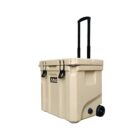 A beige wheeled cooler with a telescoping handle is shown. The cooler has a secure lid with black latches and a drainage spout. A brand logo is visible on the front.
