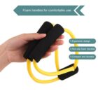 A hand holds a yellow resistance band with black foam handles. Text highlights features: ergonomic design, non-slip foam handles, and compact durability. A label reads, Foam handles for comfortable use.