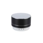 A compact, cylindrical portable speaker with a sleek black body and a silver top grille. Below the speaker, there are buttons labeled M, Previous, and Next.