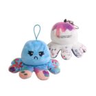 Two plush octopus keychains are shown. The first is blue with a sad face and floral patterns. The second is white with pink stains, a happy face, and doodles. A message on the white one reads, We’re so happy to help you turn ideas into fruition :).