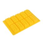 A yellow silicone mold designed to create eight brick-shaped pieces, resembling toy building blocks. Each cavity has small pegs on top, mimicking the classic design. The mold is placed on a plain white background.