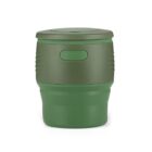 A green, cylindrical travel mug with a detachable lid sits against a white background. The mug has a matte finish with a smooth top portion, a horizontal grip band around the middle, and a slightly contoured base.