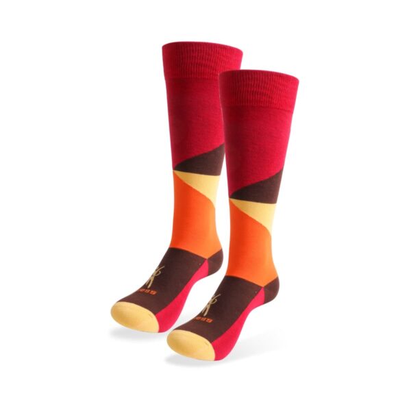 A pair of colorful knee-high socks featuring bold geometric patterns. The socks have varying shades of red, orange, yellow, and dark brown, creating a vibrant and dynamic design.