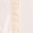 Close-up of the seam on a white fabric, featuring a light beige border on the right-hand side. The texture of the fabric is visible, highlighting the stitching detail and smooth surface.