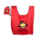 A red reusable bag with a logo of a smiling planet wearing a crown and the text SPACE QUEEN beneath it. The bag is accompanied by a matching red pouch with the same logo and text.