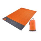 An orange and gray picnic blanket with a small attached pocket is shown laid out flat. Beside it, a drawstring bag made of the same material is standing upright.