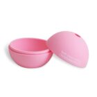 A pink, round container is open, revealing its two halves. The lid, placed beside it, reads Self care loading... with a progress bar made of hearts. The container is smooth and simple in design.