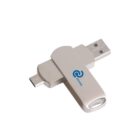 A dual USB flash drive with USB-A and USB-C connectors, featuring a rotating design and a branded logo. The flash drive is metallic gray in color and is set against a plain white background.