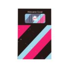 Image of a webcam cover package. The design features diagonal stripes in black, pink, and light blue. The cover is small and gray with a red and white logo in the center. It is labeled Webcame Cover at the top.