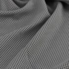 Close-up of a gray perforated fabric featuring small, evenly spaced holes. The material appears soft and slightly wrinkled, suggesting flexibility.