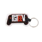 Keychain shaped like a video game controller, featuring the text FGTEEV in bold letters. The design includes a black, red, and white color scheme with a small metal ring attached for keys.