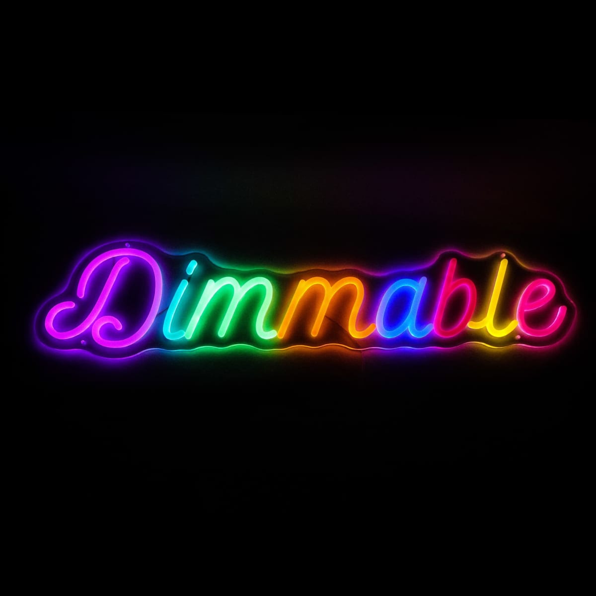 Neon sign displaying the word Dimmable in cursive script. The letters are illuminated in a gradient of colors, transitioning from purple to yellow to blue against a black background.