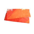 Folded orange cloth with abstract red and yellow patterns, featuring white text partially visible on the upper left corner, set against a white background.
