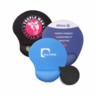 Four ergonomic mouse pads are shown: one black with pink text and logo, another blue with a white logo, a third black with a gold logo, and the fourth features blue and white colors with text listing values.