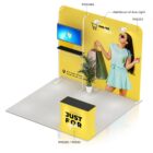 Trade show booth setup with a yellow backdrop featuring a woman in a dress holding shopping bags. The display includes a monitor and shelf labeled POS430A, an arm light labeled POS255, and a counter labeled POS320/POS92.