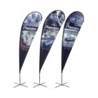 Three teardrop banners displaying the word Premier and images featuring people by the water and boats. Each banner stands on a cross-shaped base.