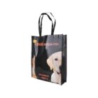 A reusable shopping bag featuring images of a dog and a cat. The bag has black handles and Hebrew text printed on it. The text and pet images suggest a theme related to animals, likely for pet supplies or animal welfare.
