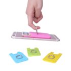 A hand holds a smartphone with a pink adhesive wallet attached, featuring a ring for grip. Three more wallets in blue, green, and yellow are displayed below, designed to hold cards and attach to phones.