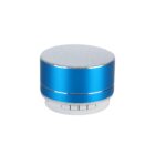 A small cylindrical Bluetooth speaker with a metallic blue finish and a silver top grille. It has three buttons at the bottom front, marked with symbols.