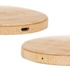 Close-up of a bamboo wireless charging pad with a USB port on one side and a small LED indicator on the other. The pad has a smooth, circular design with a natural wood finish.
