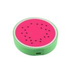 A round, flat object resembling a watermelon slice with a pink center and black seeds, encased in a green plastic outer ring.