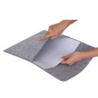 Hands holding a gray felt laptop sleeve with its flap open, revealing a smooth inner lining. The sleeve appears soft and is designed to protect a laptop.