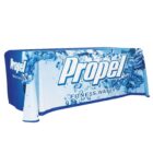 A table covered with a blue and white tablecloth displaying the Propel logo and text Fitness Water. The design features splashing water graphics, emphasizing hydration and fitness themes.