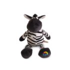 Stuffed toy zebra with black and white stripes, large ears, and a playful expression. Its right foot features a colorful emblem. The toy is seated on a plain white background.