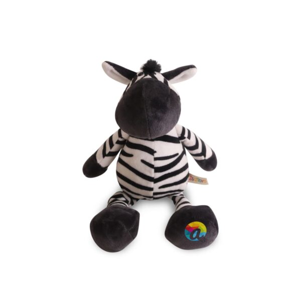 A plush zebra toy with black and white stripes sitting upright. It has a tag attached to its side and colorful letter a logo on one of its feet. The zebra has a black tuft of hair on its head and large, soft ears.
