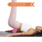 A person wearing a white top and pink leggings lies on a mat, lifting their legs vertically. A pink yoga block supports their lower back. An arrow-shaped label above reads, Help beginners to support the body while exercising.