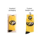 Two yellow socks with black toe and heel areas. The left sock is in standard packaging, while the right features a custom header card with a playful eye design and the text EYE & GO on a hanger.