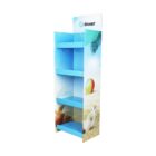 A blue cardboard display stand with three shelves, featuring a beach theme with images of a beach ball and seashells. The top has the doxer logo, and the overall design is bright and summery.