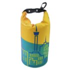 A yellow and blue dry bag with a city skyline design, featuring stylized buildings and a tower. The bag has a black buckle at the top for sealing.