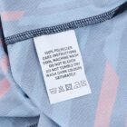 Close-up of a clothing care label on a blue fabric with pink accents. The label states 100% polyester and includes instructions for cool machine wash, no bleach, no tumble dry, and washing dark colors separately, alongside care symbols.