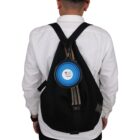 A person wearing a white shirt and black backpack is shown from behind. A collapsible blue bowl is attached to the backpack. The bowl features a logo with a heart and paw print design.