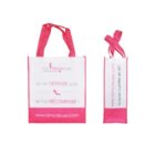 Two pink and white tote bags with the logo La Modeuse printed on them. The bags have text in French: Je ne DÉPENSE pas. Je me RÉCOMPENSE! www.lamodeuse.com La mode à portée de clic!.