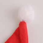 Close-up of the tip of a red Santa hat with a fluffy white pom-pom attached, set against a plain white background.