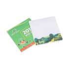 Two notepads are shown. One has a green and yellow cover with text and a cartoon character. The other is white with a green and yellow camouflage design at the bottom. Both are branded Smiggle.
