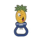 A cartoon pineapple-shaped bottle opener, featuring a winking pineapple face with a green leafy top. It displays the text Dole Plantation Hawaii on a blue base.