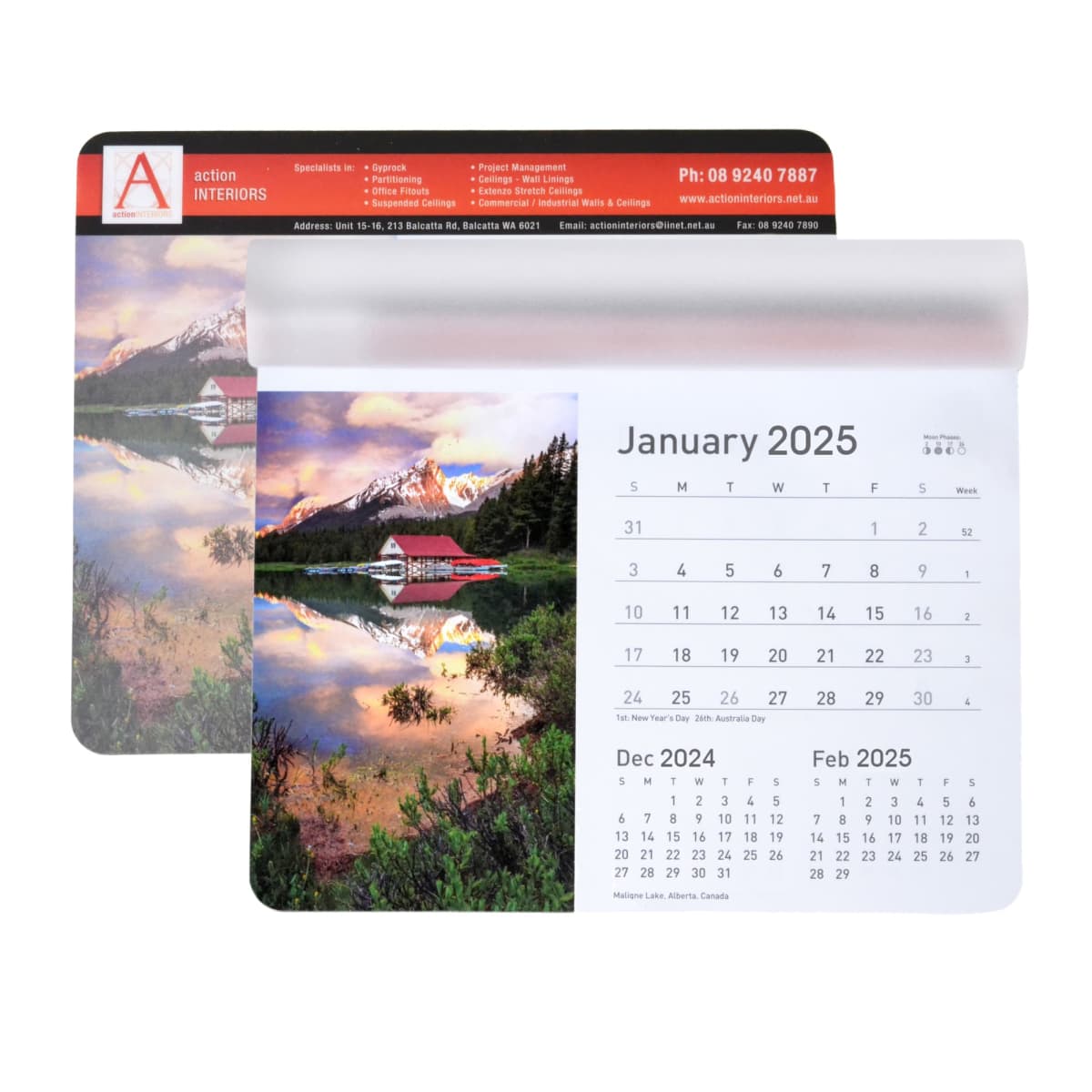 A 2025 calendar page showing January, featuring a serene lake scene with a red cabin and snow-capped mountains. The previous page shows December 2024. Both pages have a header with company details and contact information.