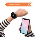 A person wearing a striped shirt holds a smartphone and a smartwatch. The smartphone screen displays weather information, and the smartwatch screen shows a message. An arrow above reads Bluetooth connection.