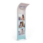 A freestanding display with three photos of people using laptops. The text at the top reads Ergonomic Comfort: Soft memory foam pad and adjustable headband for kids, toddlers, teens. The design is sleek with a gradient from white to blue at the base.