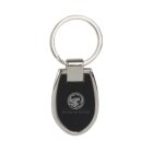 Silver and black keychain with a circular emblem and the words Premium Brand on the black surface. The keyring is metallic and attached to the top.
