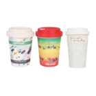 Three colorful cups with lids. The first cup has a white lid and a pattern of multicolored ovals. The second cup features a red lid and a bright, triangular design. The third cup has a white lid and a light blue floral pattern with text.