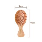 A wooden hairbrush with a curved handle, featuring beige bristles with rounded tips. The brush is labeled with the brand name Caxa and measures 14cm in length and 6cm in width.